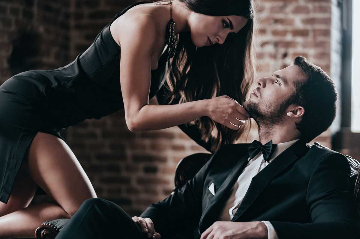 Sensual brunette escort gently guiding a shy man in a romantic Amsterdam setting